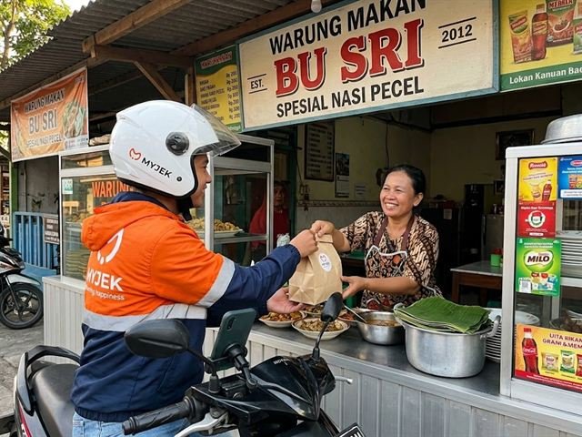 Rider MyJek mengambil pesanan dari pemilik warung makan lokal